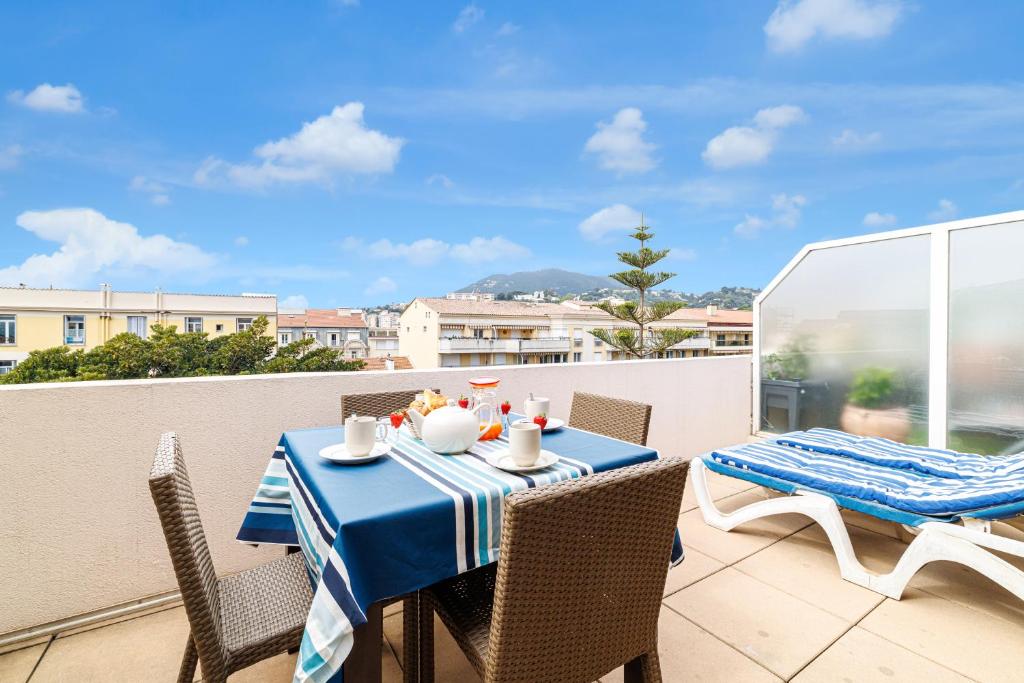 une table avec un chiffon de table bleu et blanc sur un balcon dans l'établissement 902 - Apartment top floor with AC, à Menton