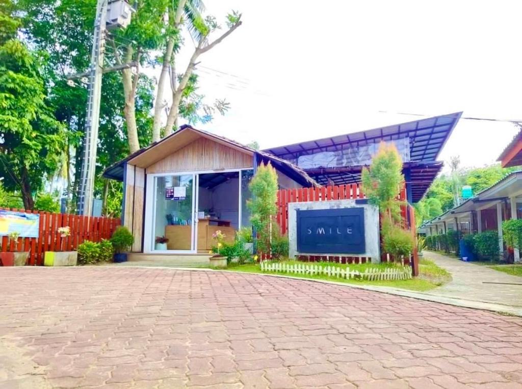 a house with a red fence and a brick driveway at Smile Resort Koh Mook in Koh Mook
