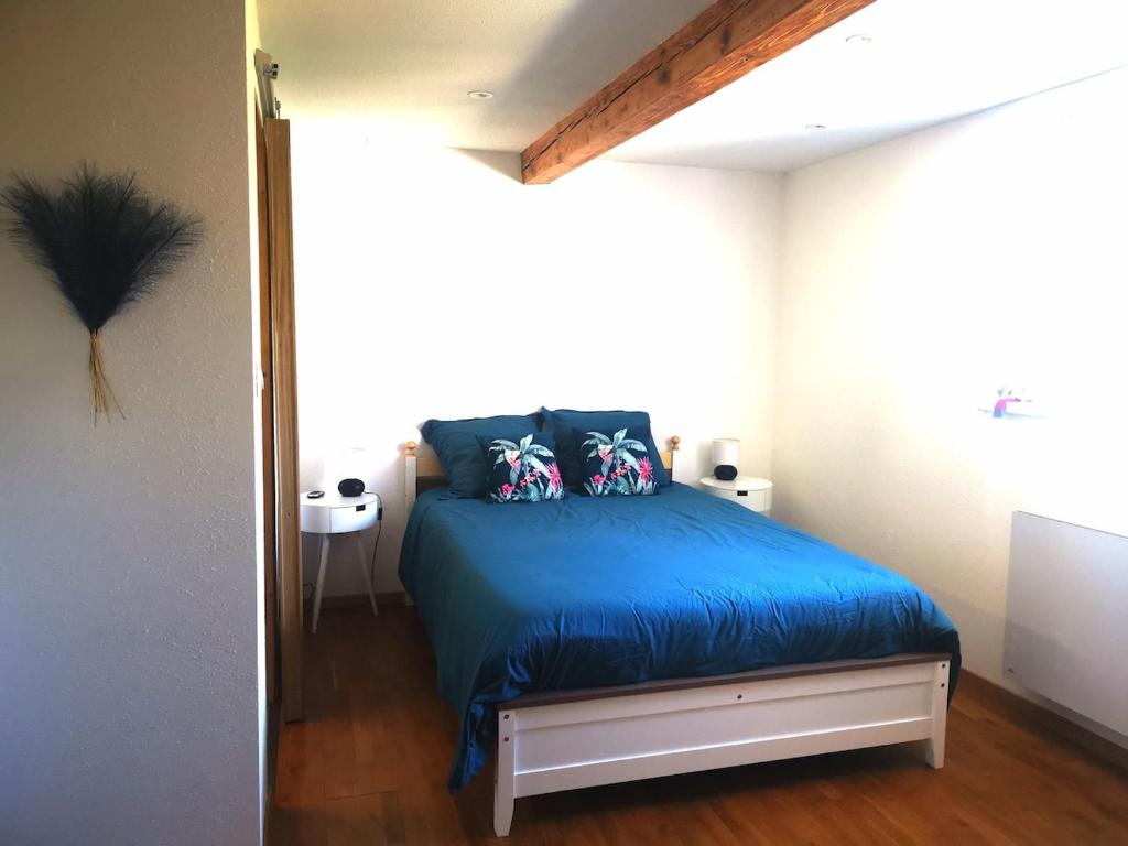 - une chambre avec un lit bleu dans l'établissement Joli meublé calme et proche commodités, à Mulhouse