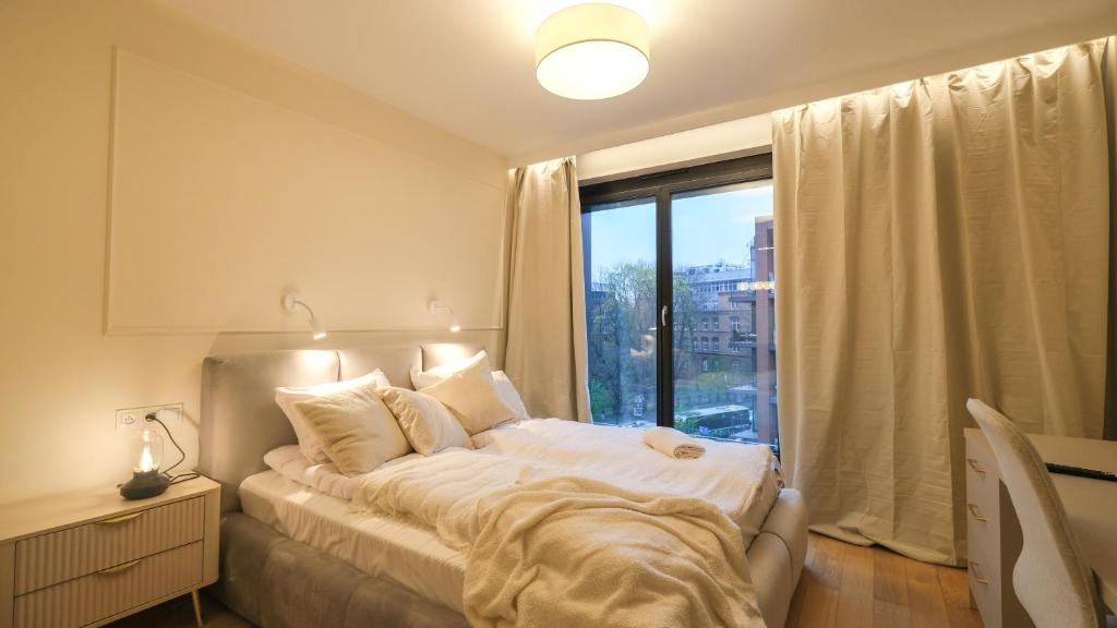 Un dormitorio con una cama y una ventana grande. en Angel's apartments - by Hosty, en Cracovia