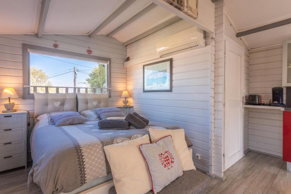 une chambre avec un lit avec des draps bleus et une fenêtre dans l'établissement Chalet De Charme Tout Confort, à Les Adrets-de-l'Estérel