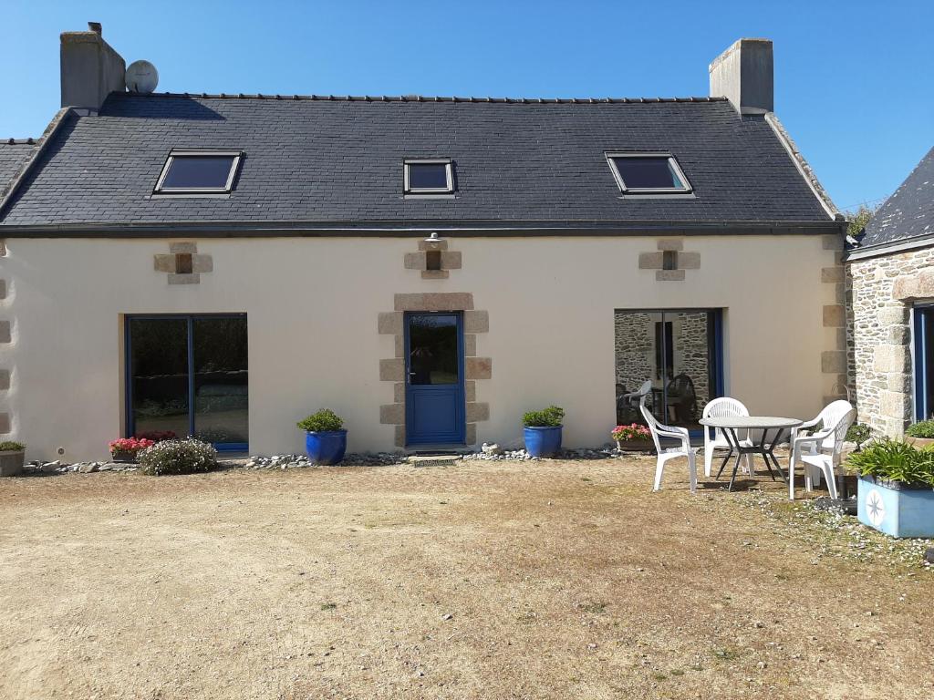 une maison blanche avec une table et des chaises dans l'établissement Maison de vacances, à Tréguennec