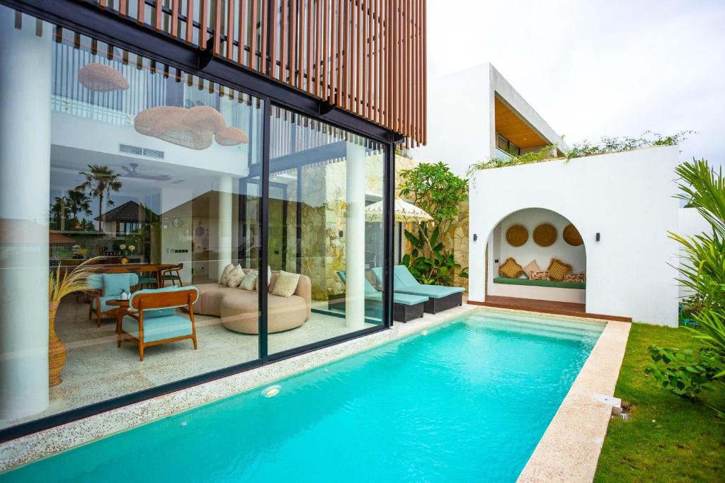 a house with a swimming pool in a yard at Villa Oria Canggu - Brand new 3BR mediterranean Villa with Ricefield sunset view in Kerobokan