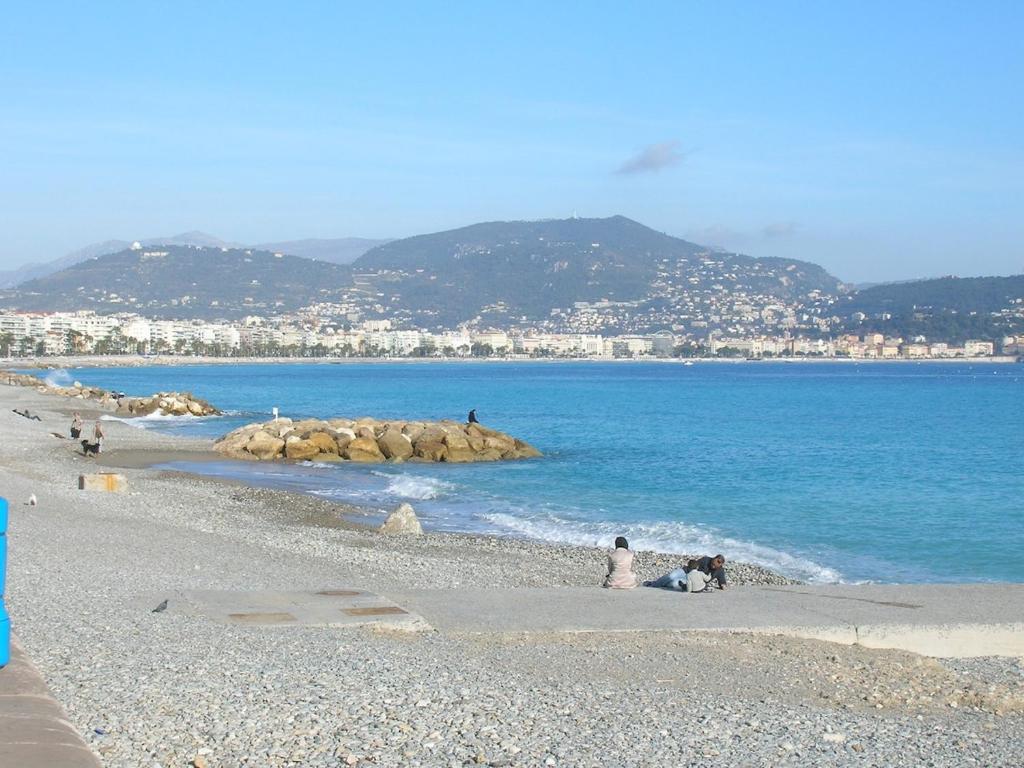 un groupe de personnes sur une plage près de l'eau dans l'établissement Nice, appartement 3 pièces à 500m des plages, à La Celle-sous-Gouzon
