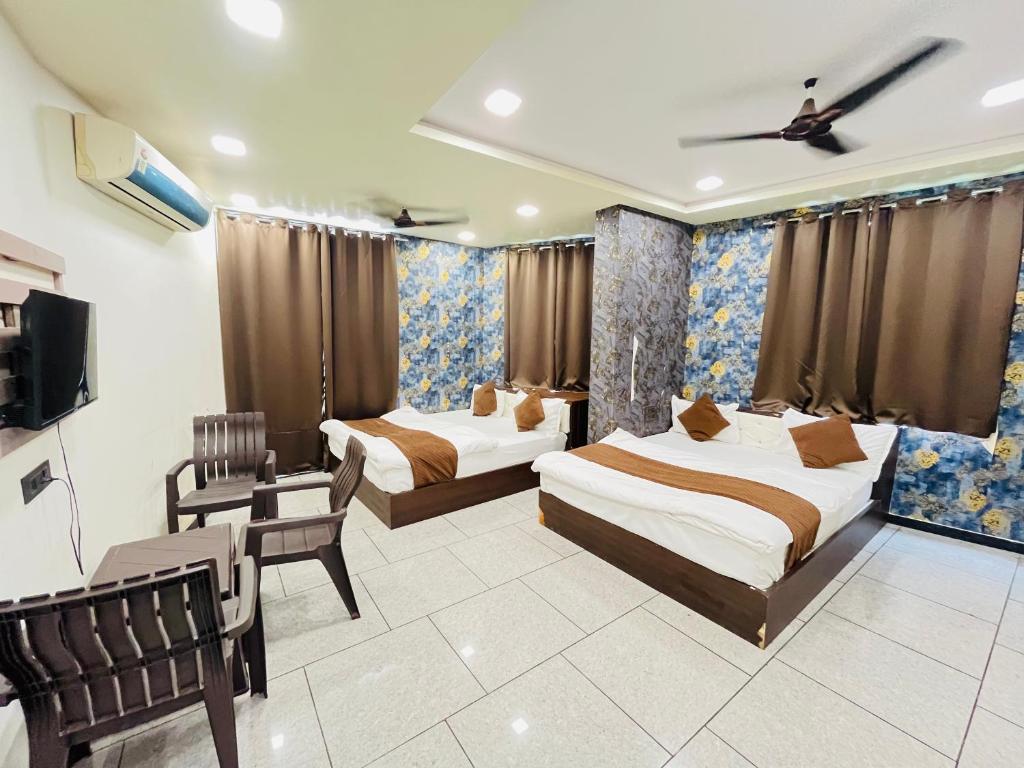 a hotel room with two beds and a tv at Hotel Shree Vijay I g66ogoIoo6 just 100mtr from temple 1min away in Nāthdwāra