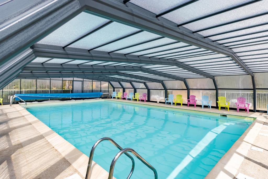 une grande piscine avec chaises et tables dans l'établissement Mobilhome Malaga Clim Trio, à Bouzic