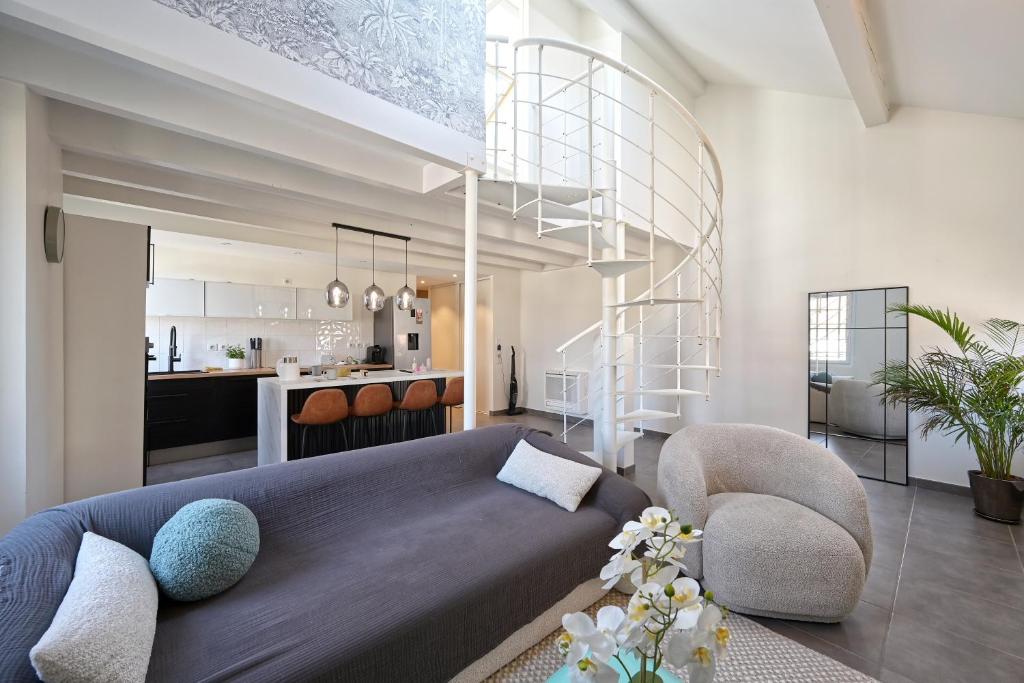 un salon avec un canapé bleu et une cuisine dans l'établissement Le Pamela - Appt climatisé, à Aix-les-Bains