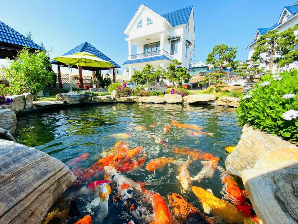 un étang avec des cerfs-volants en face d'une maison dans l'établissement Villa &Coffee Garden, à Xuan An