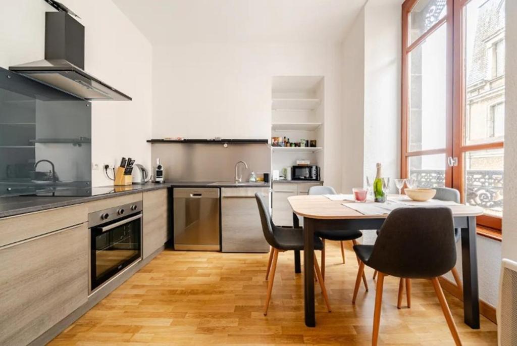 une cuisine avec une table et des chaises dans une pièce dans l'établissement Nouveau T2 Centre Historique, à Thiers