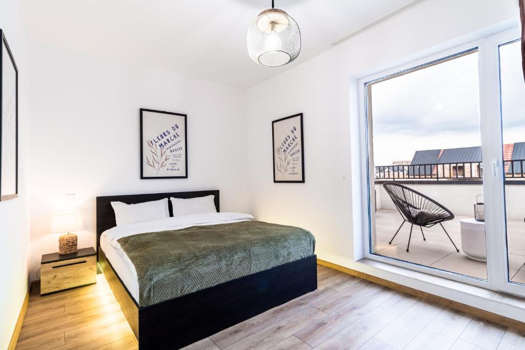 a bedroom with a bed and a large window at Skylark - Cairo Penthouse cu Jacuzzi si Vedere la Munte in Braşov