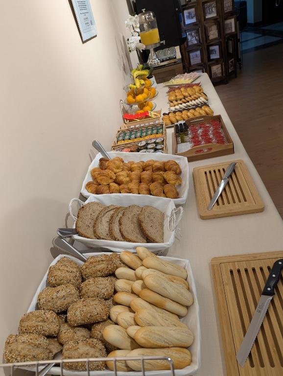 a buffet line with different types of bread and pastries at Hotel de Francia y París in Cádiz