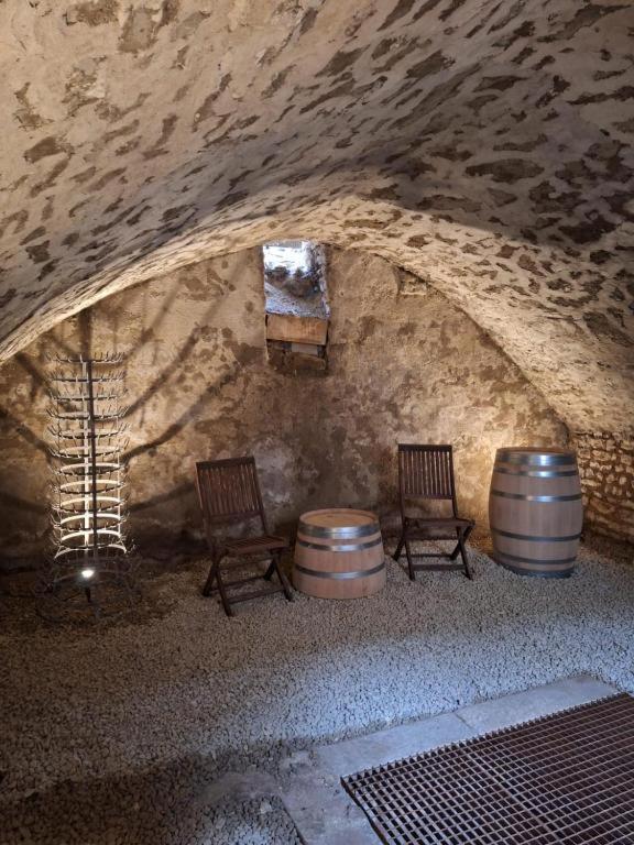 deux tonneaux de vin et deux chaises dans une grotte dans l'établissement Les Remparts 1, à La Charité-sur-Loire