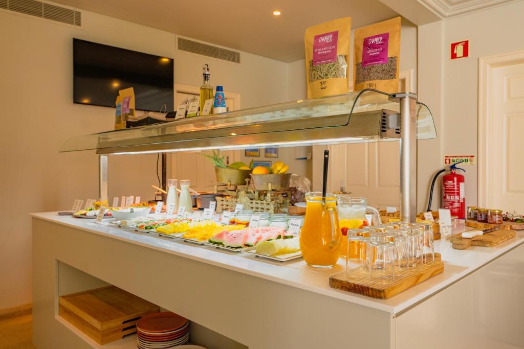 A well-stocked breakfast buffet with chilled drinks, pastries, fruit and tableware.