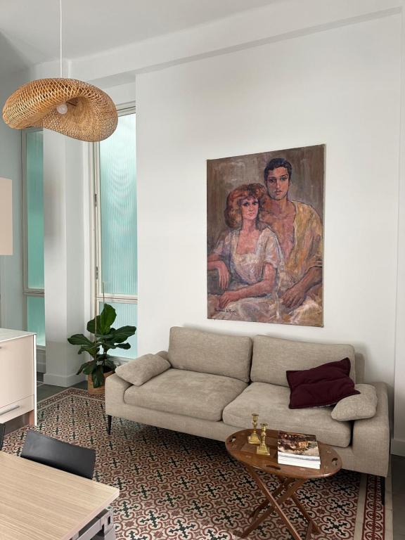 Hotel Unique Sevilla, a living room with a couch and a painting on the wall at Unique Sevilla in Seville