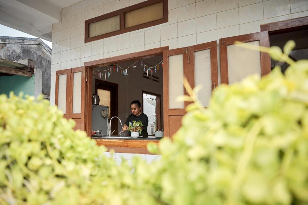 eine Person in einem Spiegel in einer Küche in der Unterkunft Mit Homestay Phú Quý in Cu Lao Thu