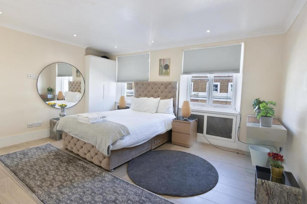 a bedroom with a large bed and a mirror at Gucci flat in Knightsbridge in London