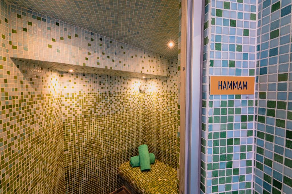 A colourful tiled hammam with a built-in green mosaic seat.