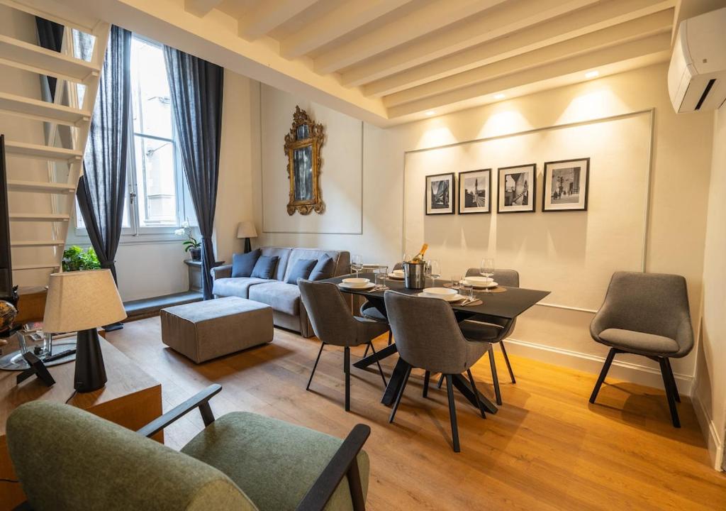 ein Wohnzimmer mit Tisch und Stühlen und einer Couch in der Unterkunft Maison Luxury Suite - Duomo in Florenz