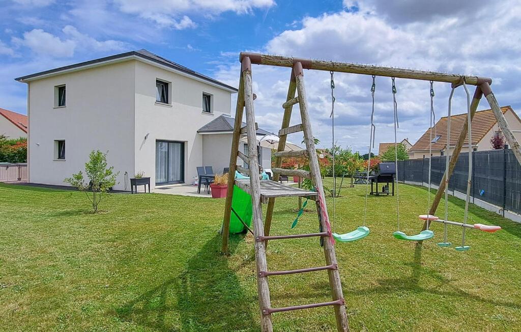a playground with a wooden swing in a yard at L'Air de Caen in Esquay-Notre-Dame