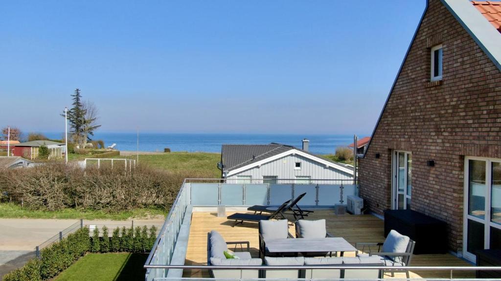 a house with a deck with a view of the ocean at Am Dahmer Leuchtturm 23c in Dahme