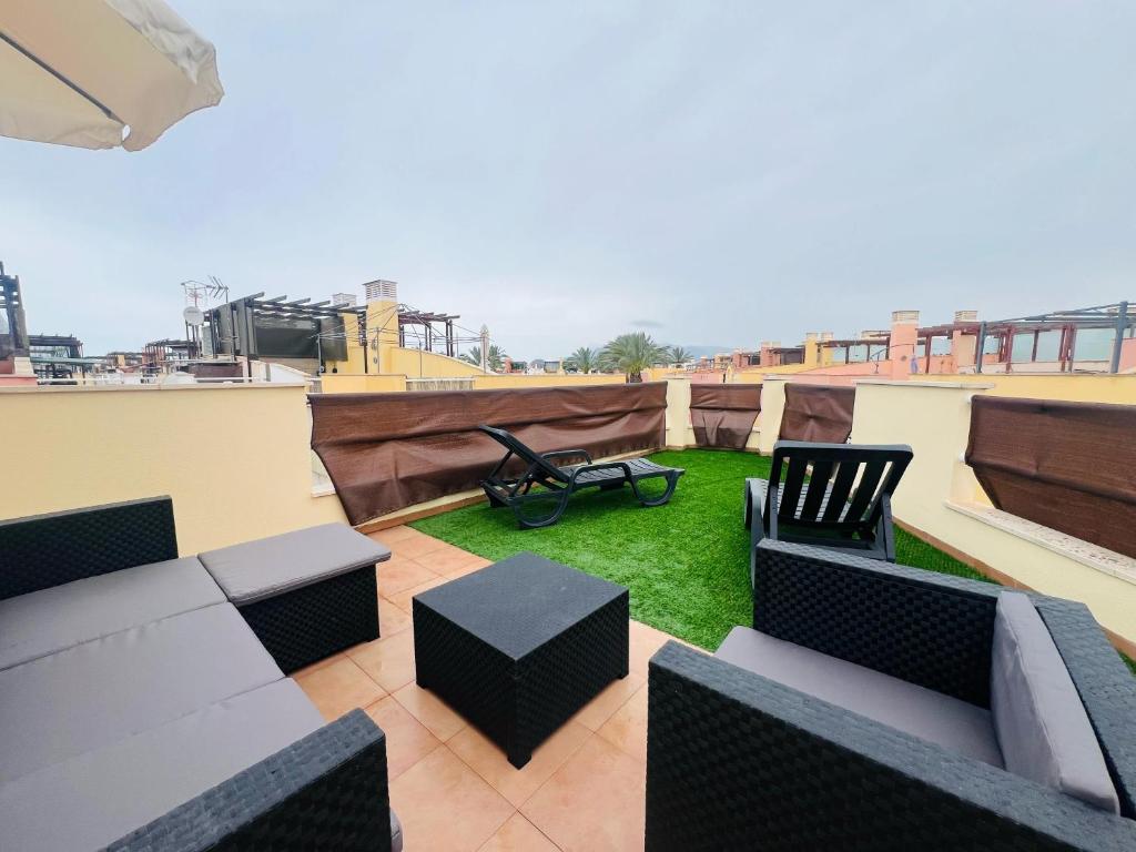 a rooftop patio with furniture and grass on a roof at Vera Albacora de Luxe in Vera