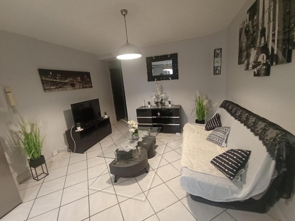 un salon avec un canapé et une télévision dans l'établissement Appartement traquille, à Toulon