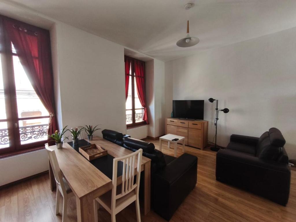 un salon avec une table et un canapé dans l'établissement Nouveau T3 Centre Historique, à Thiers