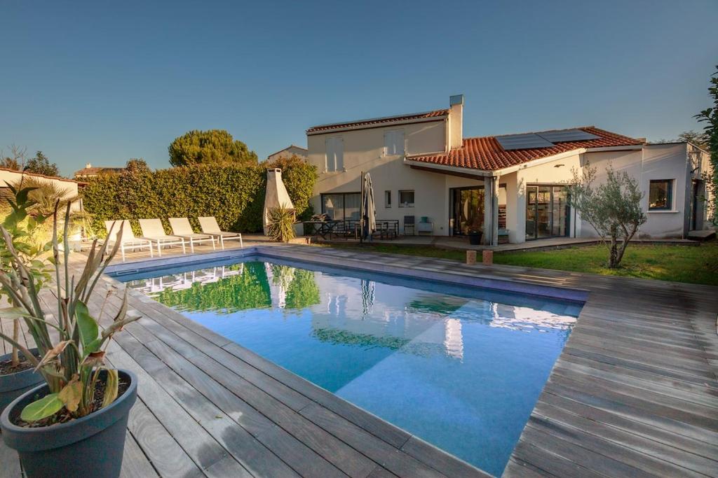 une piscine devant une maison dans l'établissement Villa avec piscine au charme authentique et naturel, à Baillargues