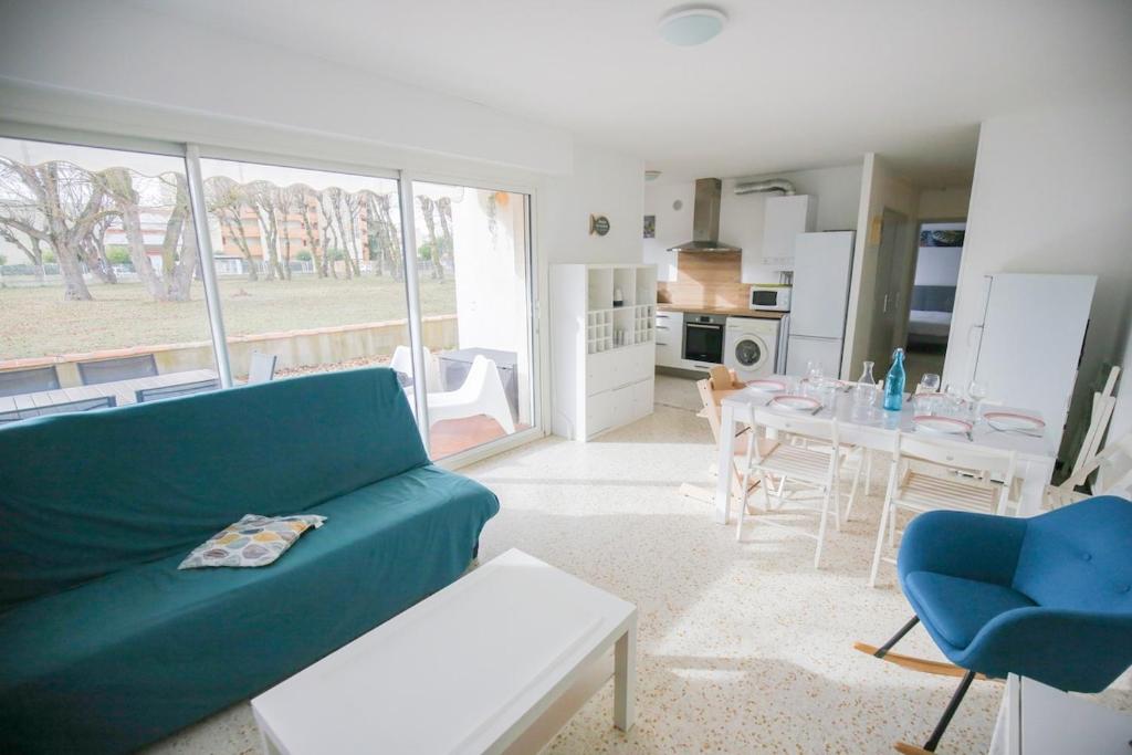 un salon avec un canapé vert et une table dans l'établissement Le Fenouil, au Grau-du-Roi