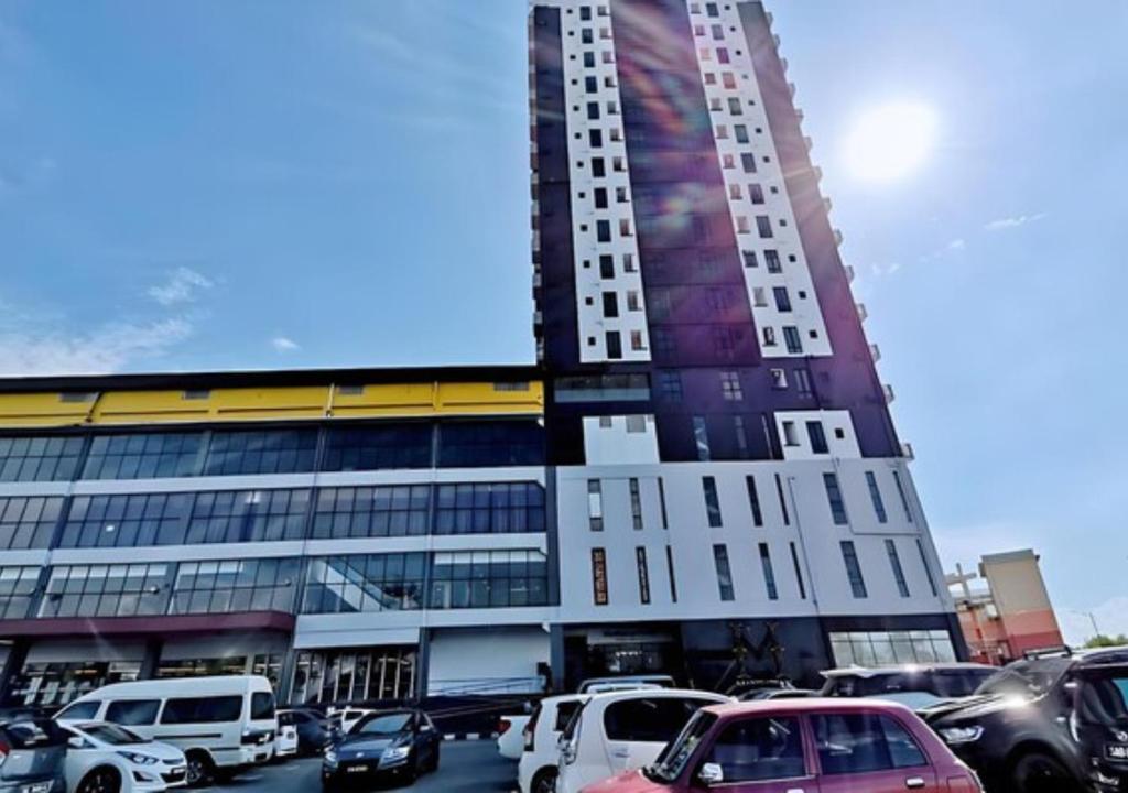a tall building with cars parked in front of it at ITCC Manhattan by IGVC in Penampang