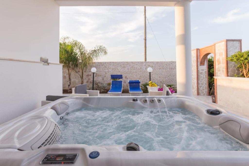 un jacuzzi en un patio con sillas azules en Luna Rossa Salento, en Porto Cesareo