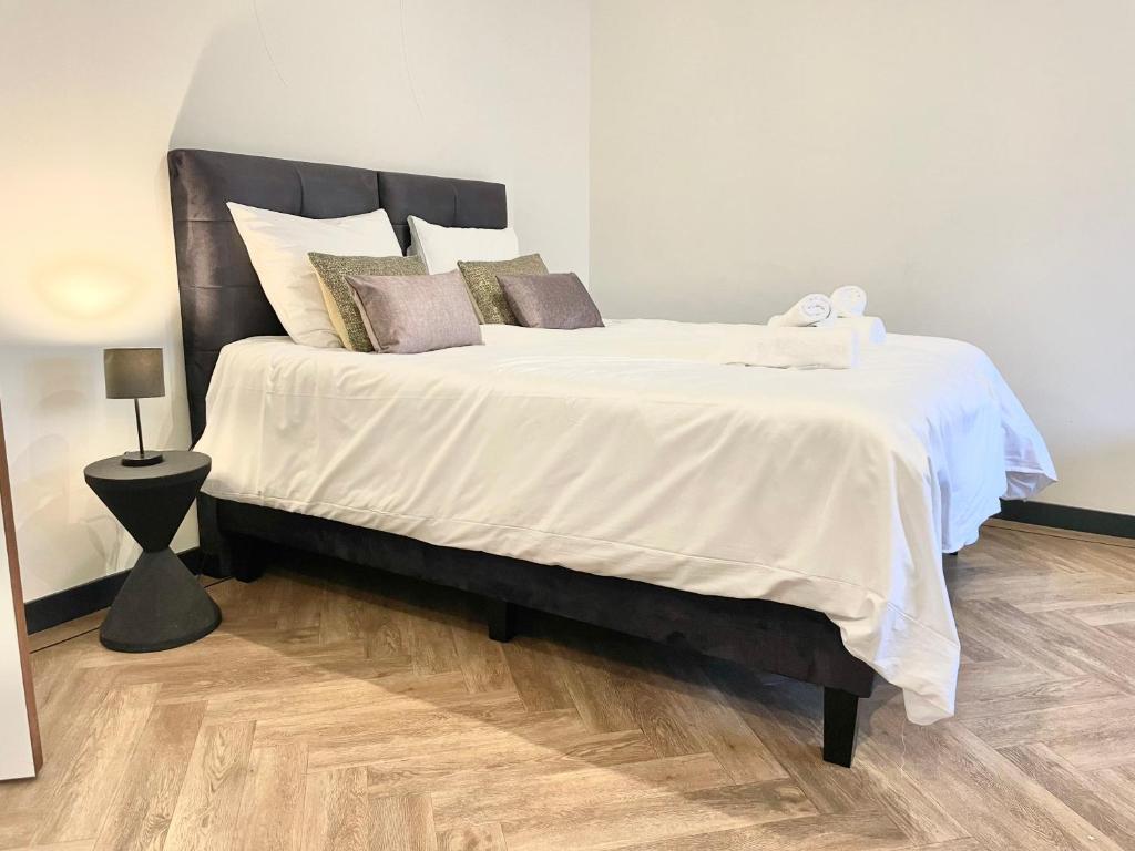 a bedroom with a large bed with white sheets and pillows at Stylish Studio with Balcony, Near Tilburg Station in Tilburg
