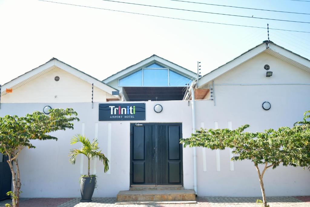 une maison blanche avec un panneau indiquant la limite dans l'établissement Triniti Airport Hotel, à Dar es Salaam