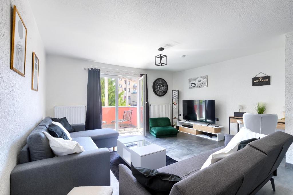 un salon avec deux canapés et une télévision dans l'établissement Saint Maurice Design Home, à Stiring-Wendel
