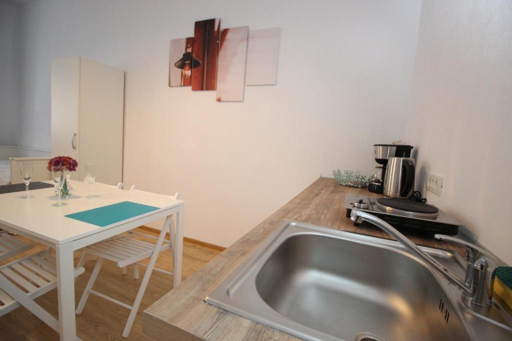 a kitchen with a stainless steel sink and a table at Under Tampa Grand Studio in Braşov