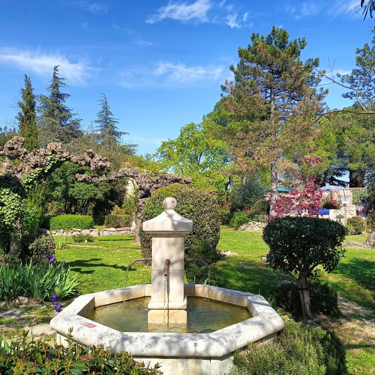 ein Brunnen mitten in einem Garten in der Unterkunft Gîte en Ardèche Méridionale - Les Berbéris in Chandolas