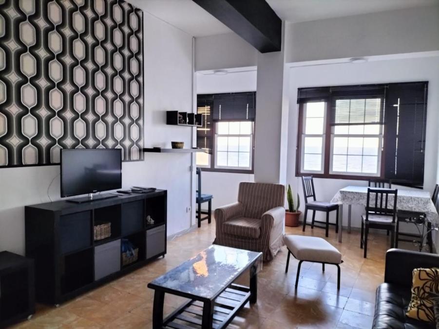 a living room with a couch and a tv and a table at Avenida Marítima Trapiche in Santa Cruz de la Palma
