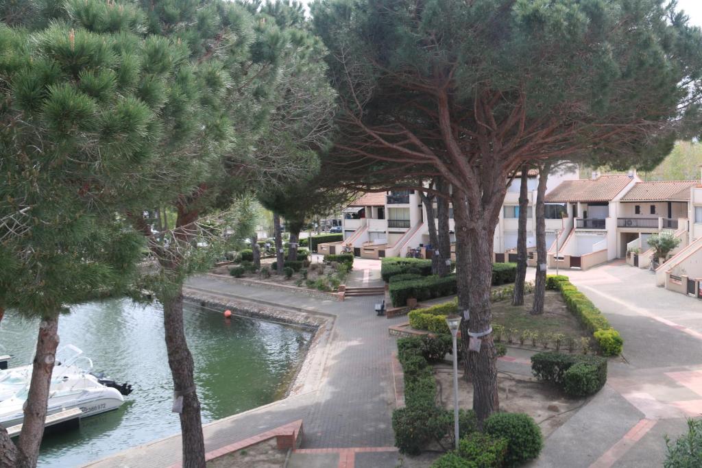 a view of a river with trees and a boat at Les Capellans, port d'attache in Saint-Cyprien-Plage