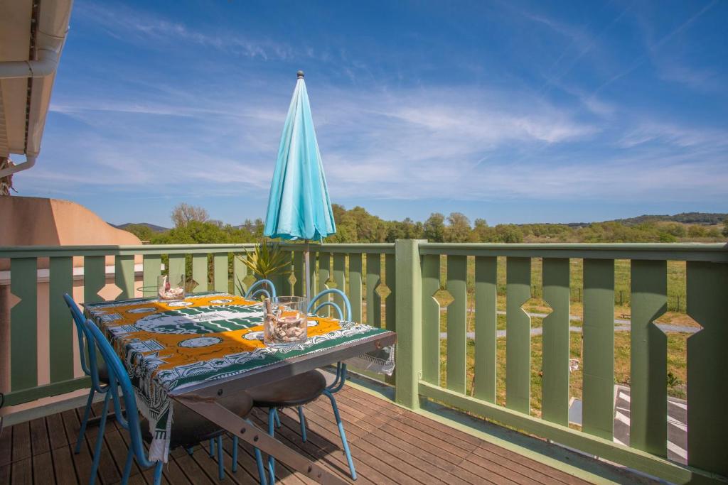 a table on a balcony with an umbrella at T3 au calme avec terrasse in Cogolin