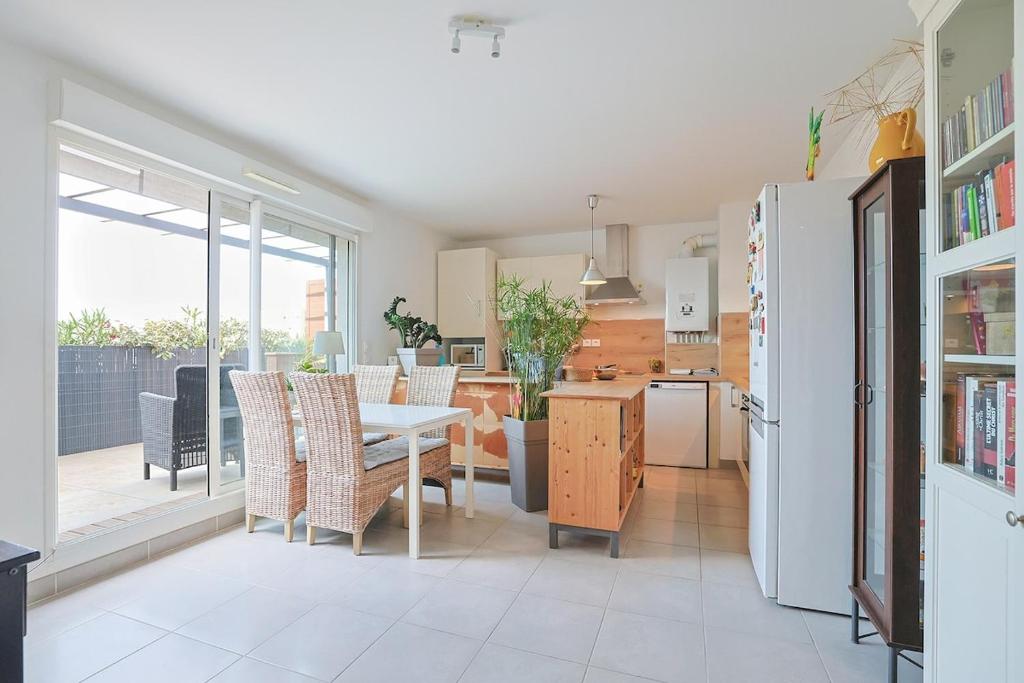 une cuisine et une salle à manger avec une table et un réfrigérateur dans l'établissement Air-conditioned south-facing apartment, à Hyères