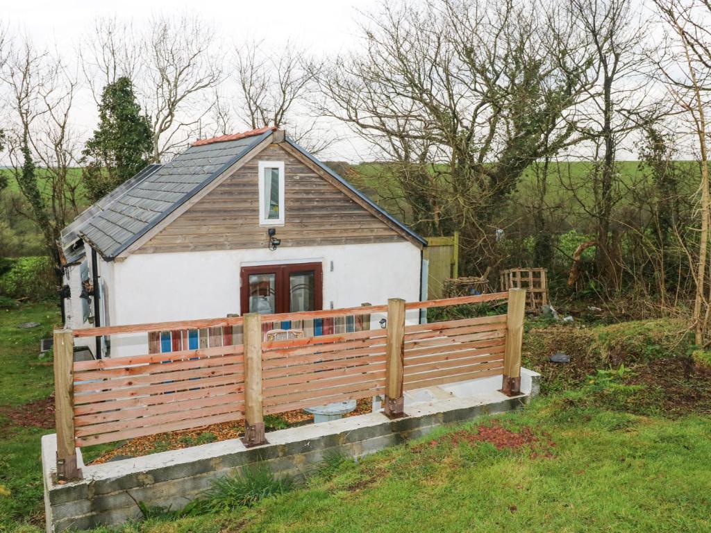 une petite maison entourée d'une clôture en bois dans l'établissement Anchor Light, à Pembroke