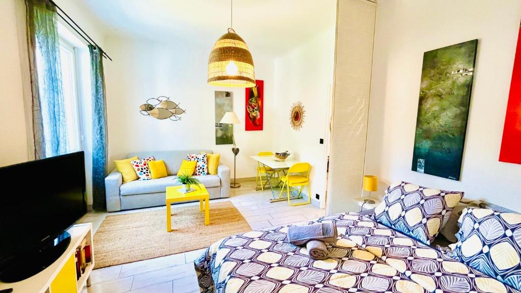 een woonkamer met een bed en een bank bij Au son des Cigales in Cassis