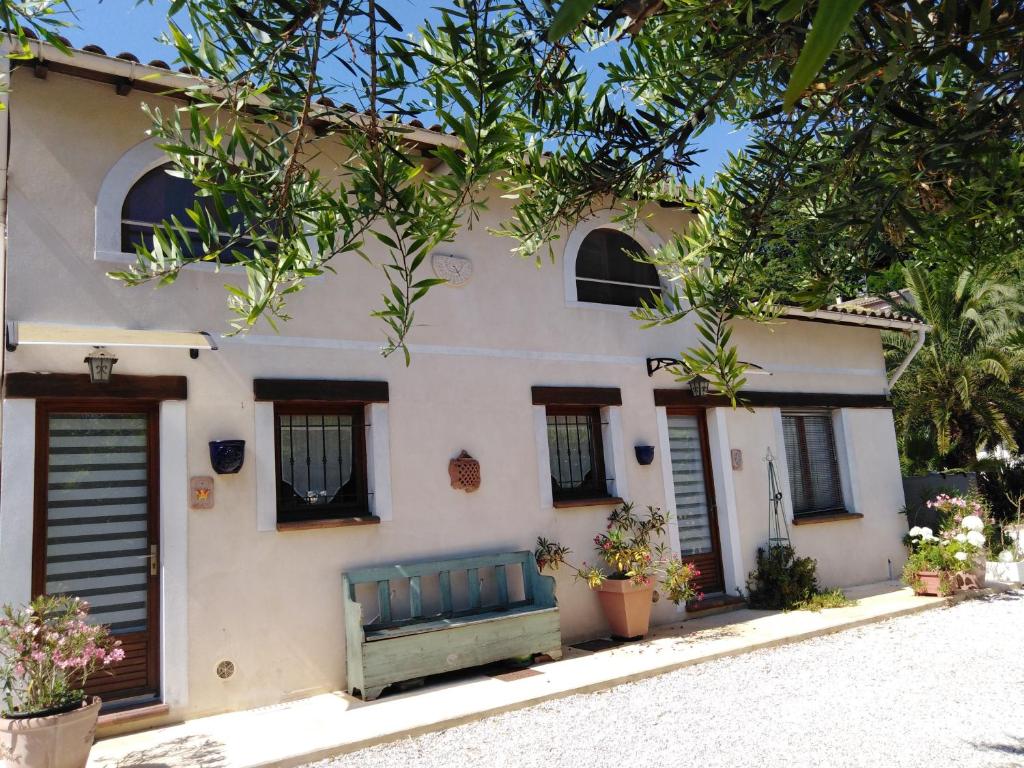 une maison avec un banc vert devant elle dans l'établissement Gîte Bastide la Palmeraie - au calme, dans propriété, parking assuré, à Saint-Paul-de-Vence