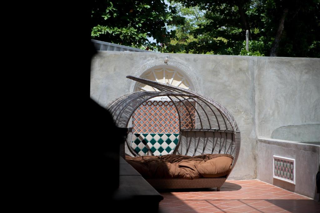 a bird cage sitting next to a wall at Jawi Peranakan Mansion in George Town