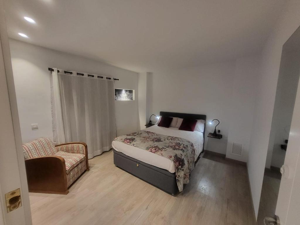 a small bedroom with a bed and a chair at Turistic Girona - Piso de 1, 2 o 3 habitaciones in Girona