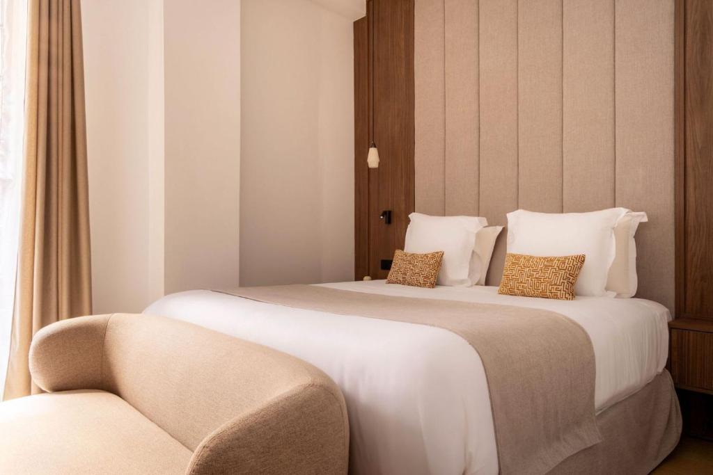 une chambre d'hôtel avec deux lits et une chaise dans l'établissement Studio exceptionnel champ de mars - paris 7 - 2p, à Paris