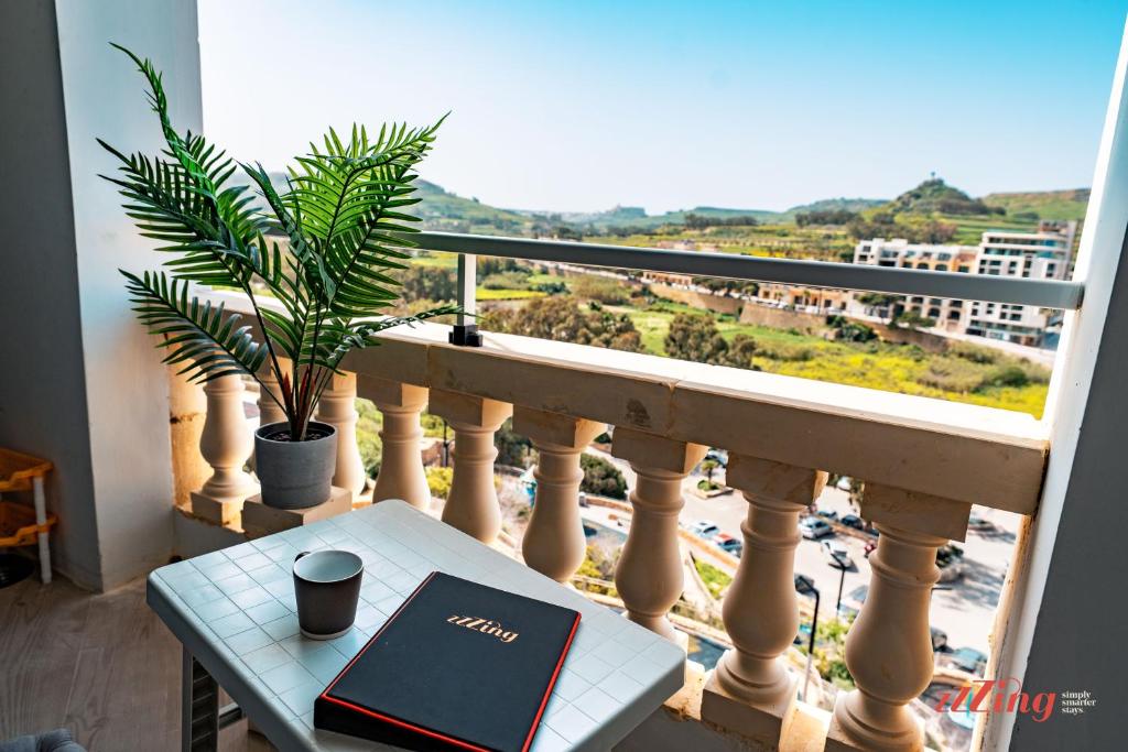 a laptop on a table on a balcony with a view at A holiday Home in Gozo Right by the Sea in Marsalforn