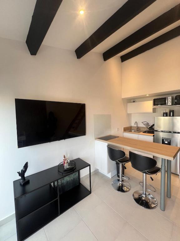 - une cuisine avec une table en bois et des tabourets de bar noirs dans l'établissement Appartement en résidence, au Cap d'Agde