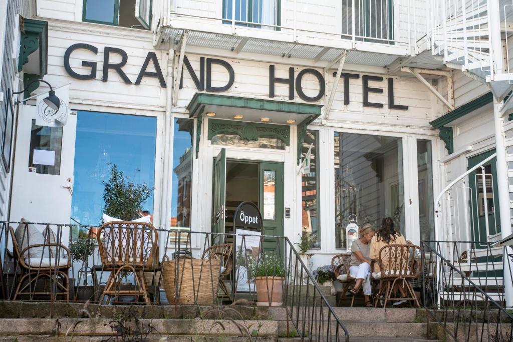 Un grupo de personas sentadas afuera de un gran hotel. en Grand Hotel Lysekil, en Lysekil