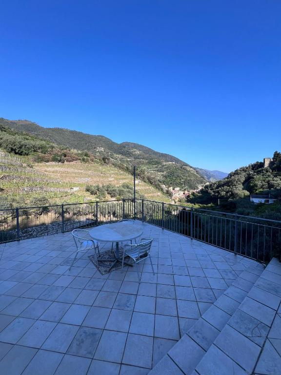 a picnic table on a patio with mountains in the background at Agriturismo Buranco in Monterosso al Mare